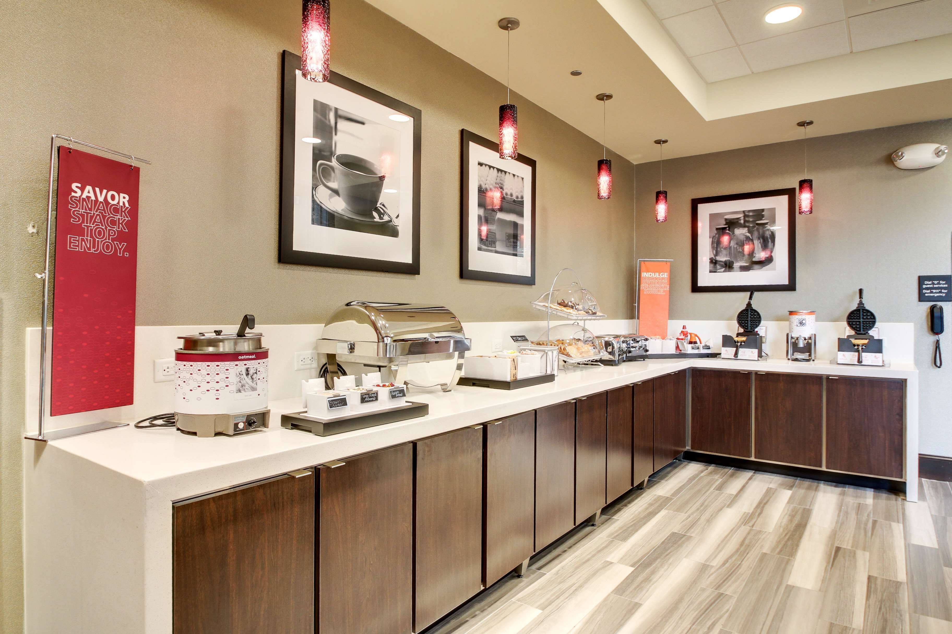 A breakfast bar with a coffee maker, a food warmer, and various breakfast items.