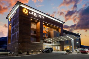 A La Quinta hotel with a modern design, featuring a prominent entrance and a covered parking area. - La Quinta Inn & Suites by Wyndham Cedar City (Cedar City)