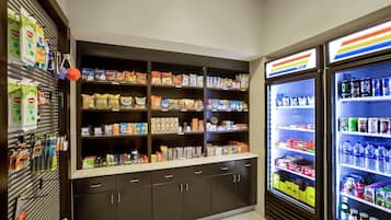 Un espace de libre-service où l'on peut se servir des boissons fraîches et où une variété de produits emballés sont présentés sur des étagères.