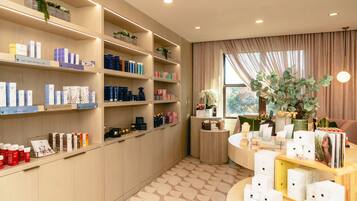 Products are neatly arranged on shelves and a central display table in this well-organized retail space.