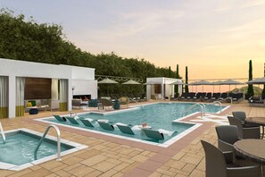 Area piscina sul tetto con sedie a sdraio, una piccola piscina e una zona relax con ombrelloni.