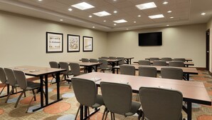 A conference room with tables and chairs, a flat-screen TV, and framed artwork on the wall. - Staybridge Suites Midland by IHG (Midland)