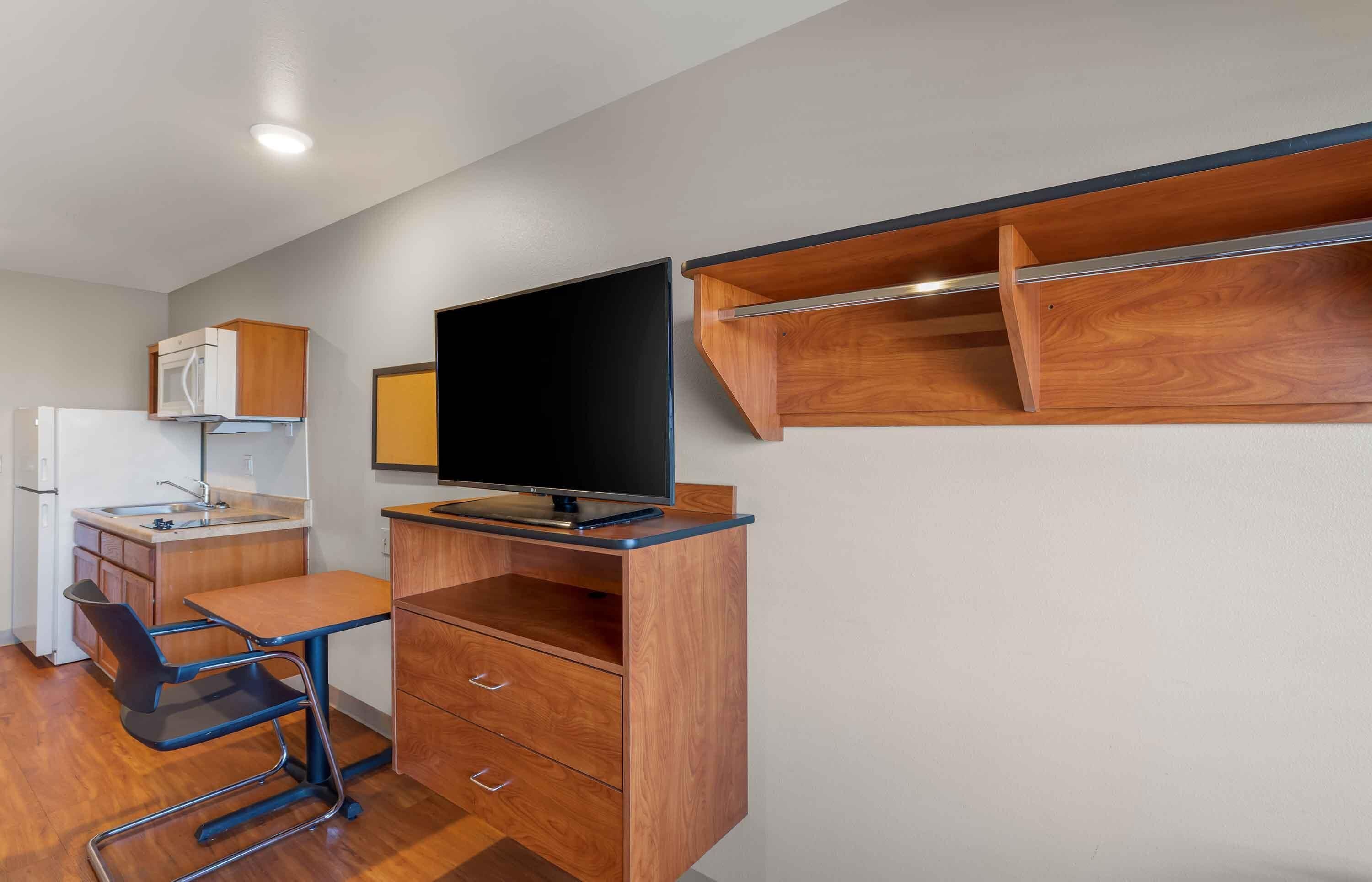A compact kitchenette with a microwave, sink, and a small refrigerator.