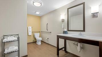 A bathroom with a white sink, a mirror, a towel rack, and a toilet.