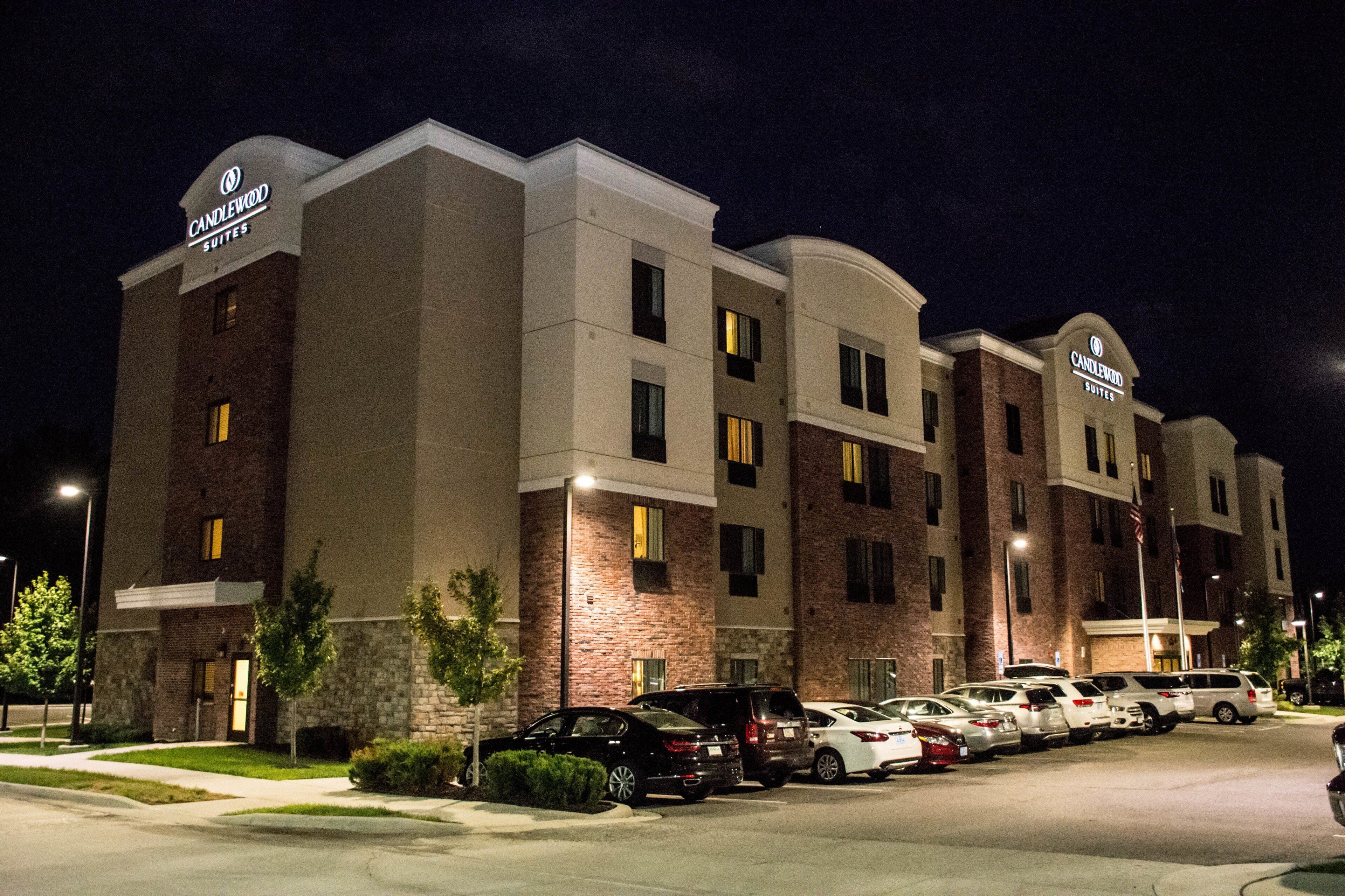 A hotel with multiple suites, a parking lot, and a brick facade.