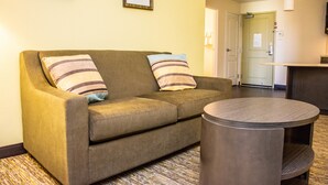 Ein Wohnzimmer mit einer Couch, zwei Kissen und einem runden Tisch.