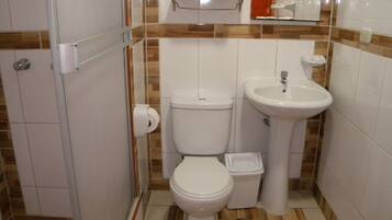 A compact bathroom with a toilet, bidet, and sink.