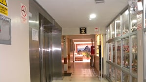 A hallway with an elevator, a sign indicating the second floor, and a glass display case with items. - Hotel Panamericano (Lima)