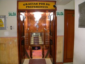 A hotel entrance with a sign reading "GRACIAS POR SU PREFERENCIA" and two "SALIDA" signs on either side.