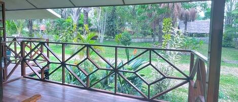 An outdoor wooden deck with a geometric railing and a canopy overhead.