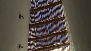 A room with a slanted ceiling, a window with wooden blinds, and a small wall-mounted light fixture. - Mi Casa en Cozumel (Cozumel)