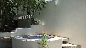 A spa area with a hot tub, stone steps, and potted plants. - Mi Casa en Cozumel (Cozumel)