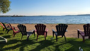 A lakeside view with several Adirondack chairs facing the water.