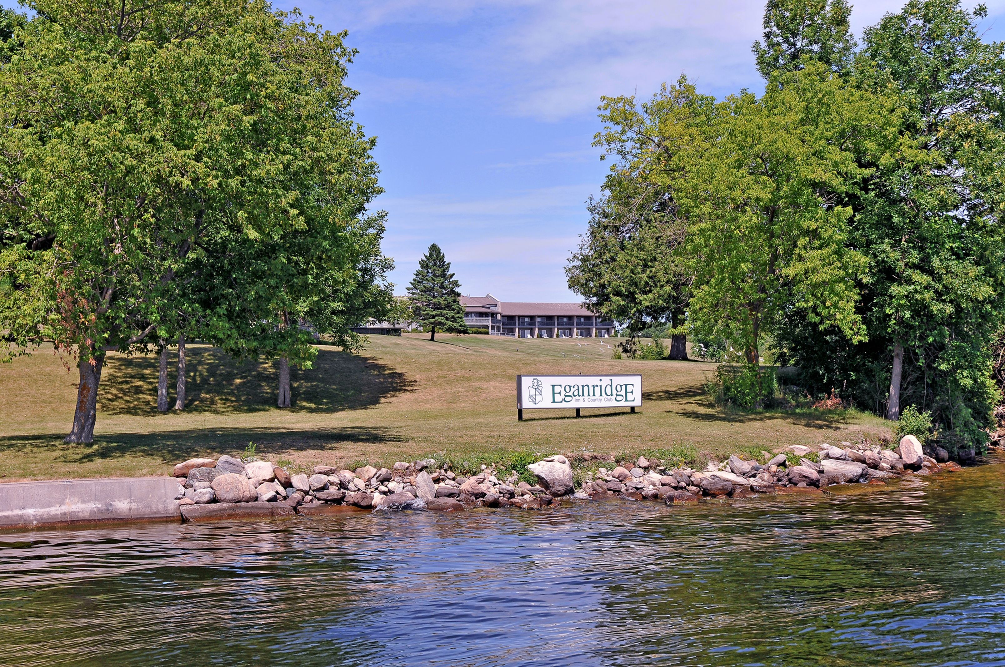 A sign for Eganridge, a building surrounded by trees and a body of water.