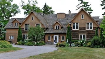 Ein großes, mehrstöckiges Holzhaus mit einer symmetrischen Fassade, zahlreichen Fenstern und einem zentralen Eingang.