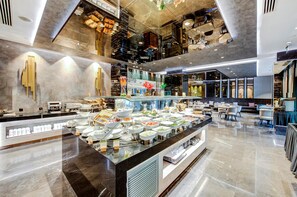 A modern hotel lobby with a buffet area, seating arrangements, and a high ceiling with exposed beams. - DoubleTree by Hilton Hotel Istanbul - Piyalepasa (Istanbul)