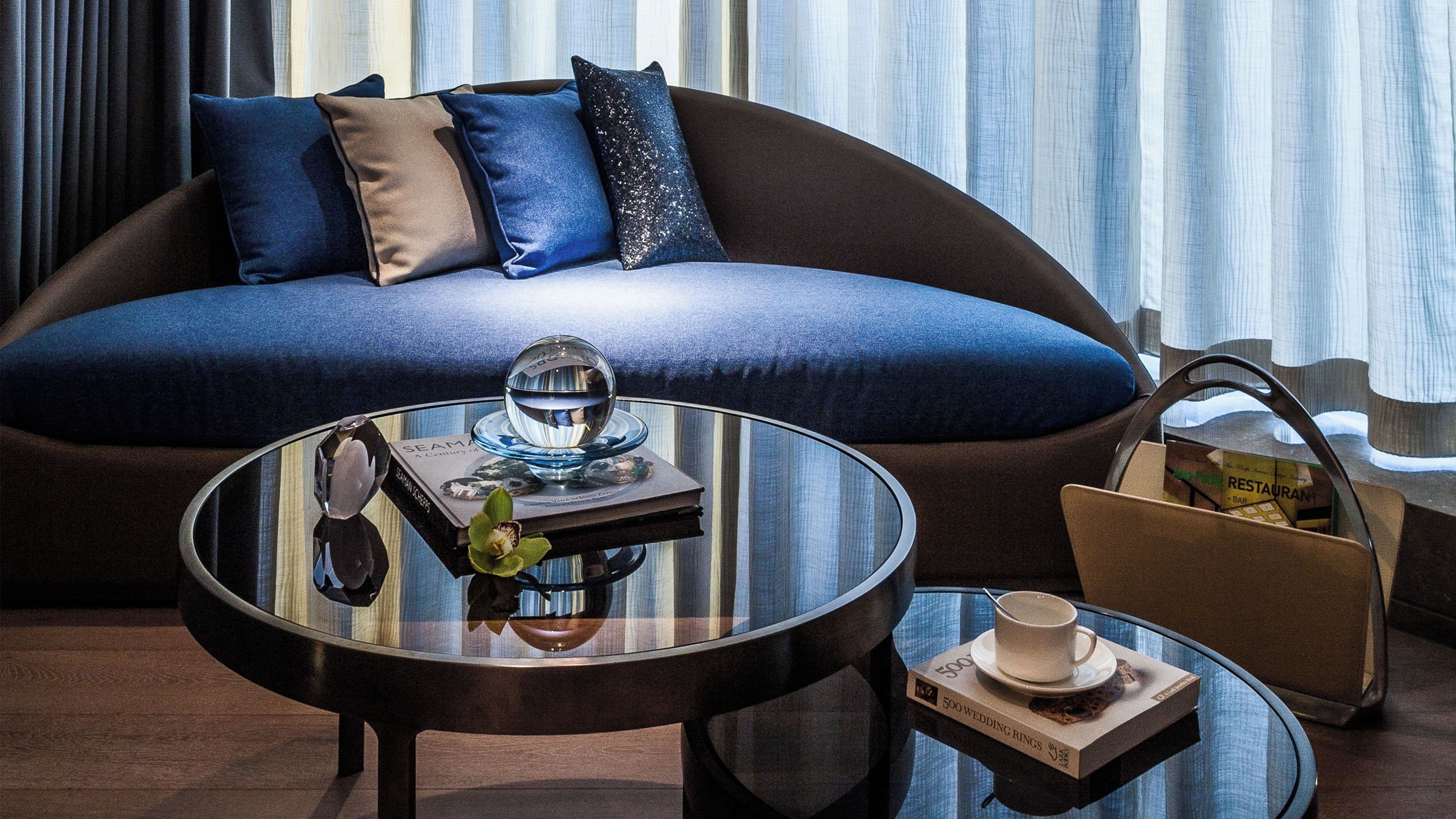 A modern living room with a sofa, a glass coffee table, and a decorative bowl.