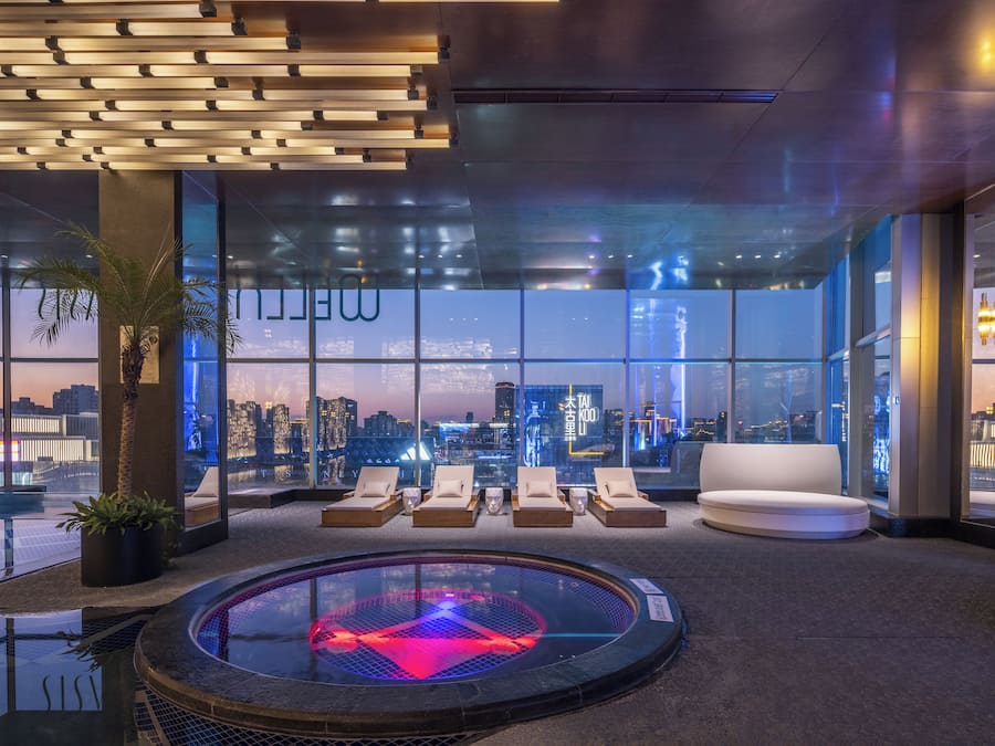 A modern lounge area with a city view, a heated floor, and a glass wall.