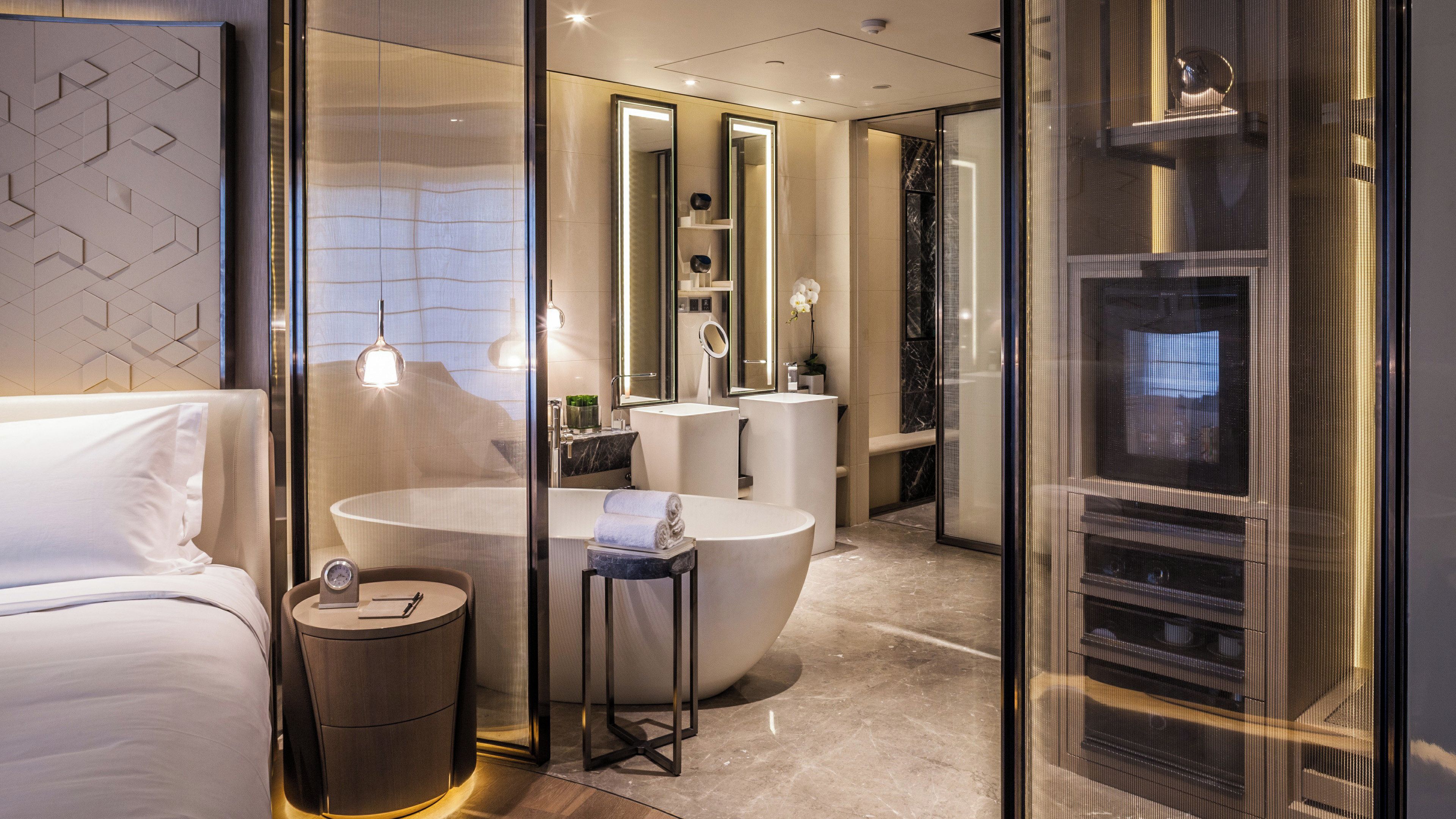 A modern bathroom with a large bathtub, a vanity with a mirror, and a toilet.