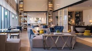 A modern hotel lobby with seating areas, a reception desk, and a large bookshelf. - InterContinental Beijing Sanlitun by IHG (Beijing)