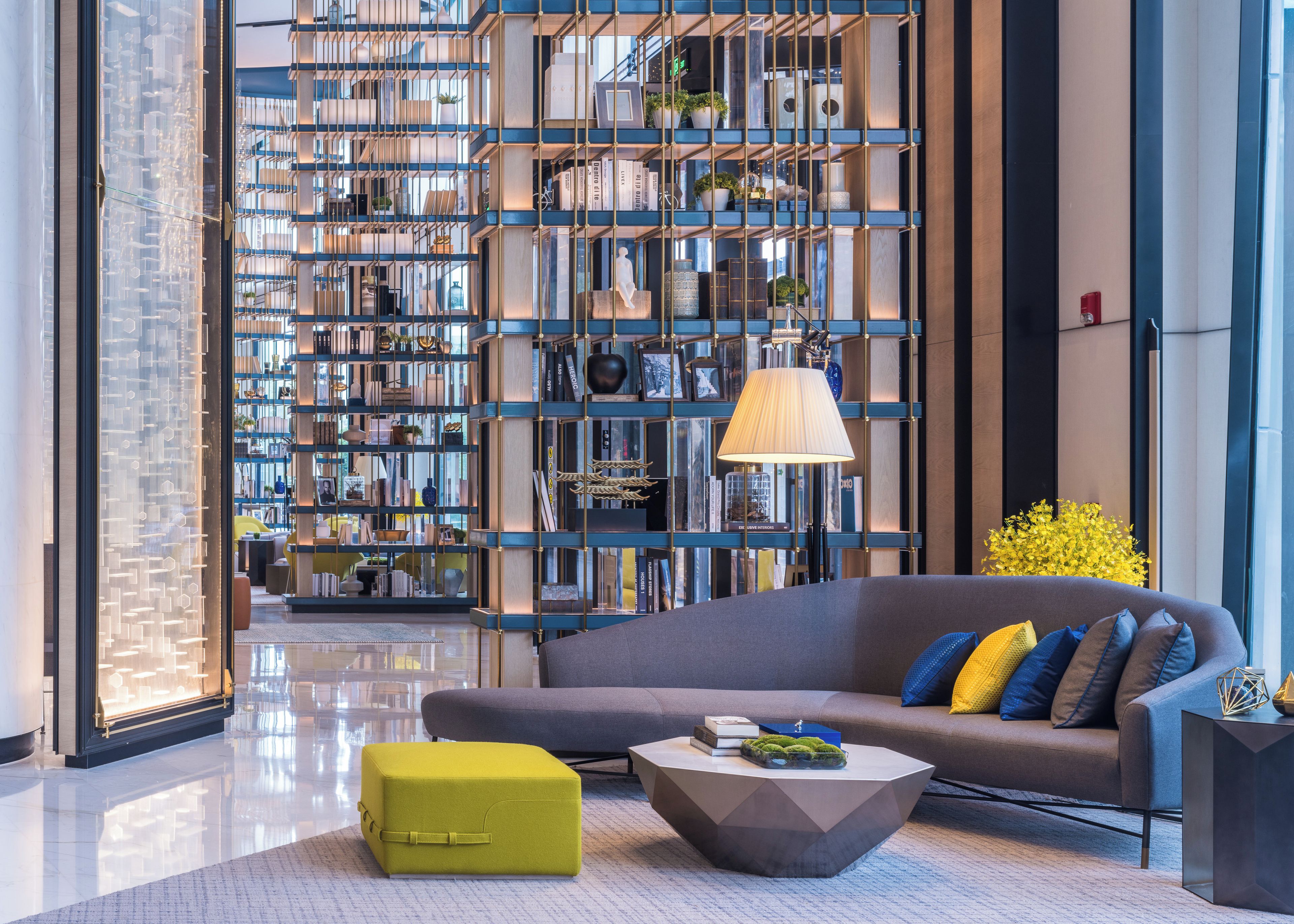 A modern living room with a large bookshelf, a sofa, and a coffee table.