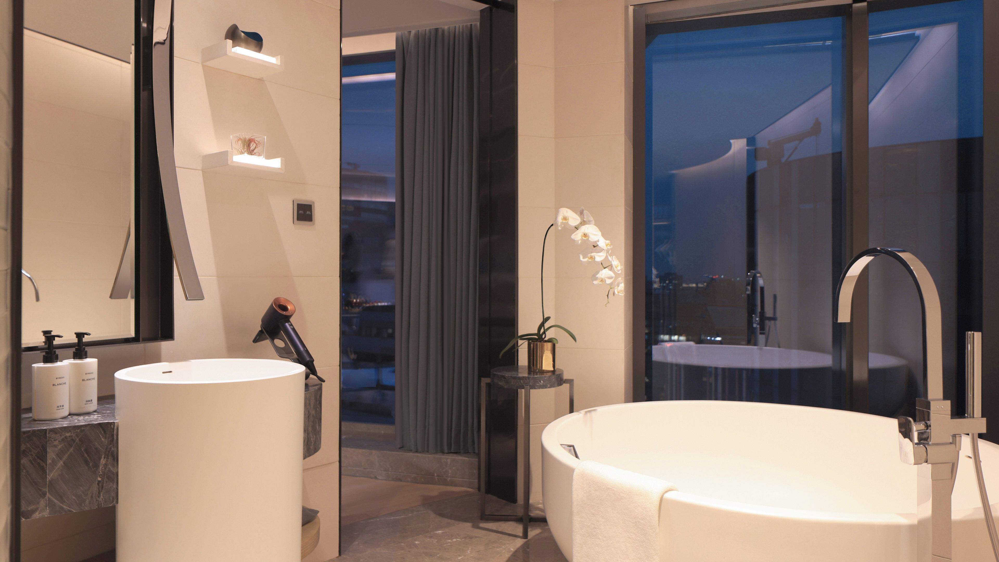 Ein modernes Badezimmer mit zwei Waschbecken, einer großen Badewanne und einem Spiegel.