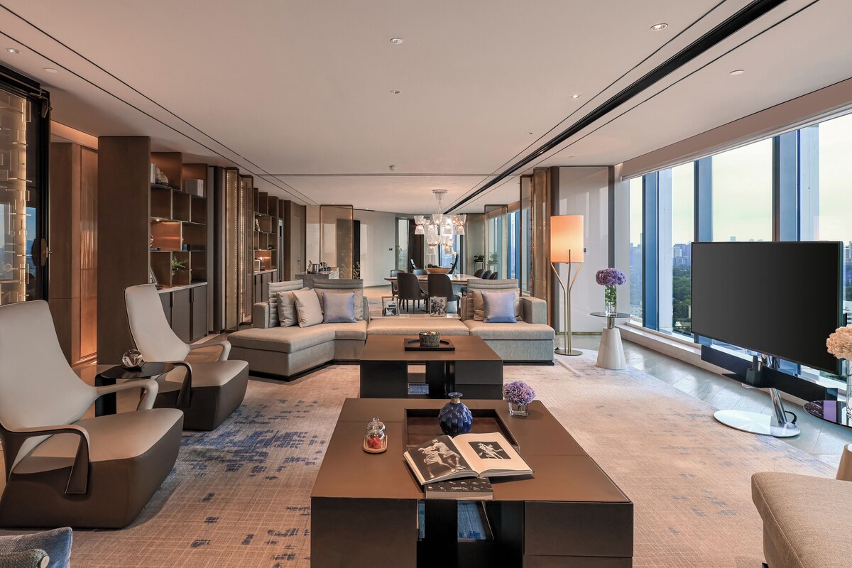 A modern living room with a sectional sofa, a coffee table, and a flat-screen TV.