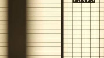 A room with a grid-patterned wall and a vertical dark column.