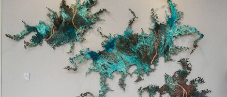Pared con arte abstracto que presenta patrones fractales en tonos azules y marrones.