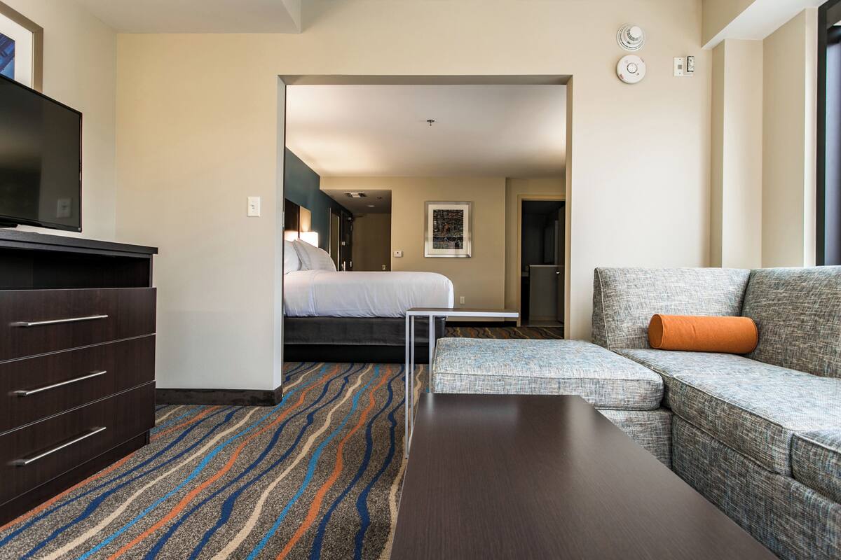 Ett hotellrum med en säng, en soffa, en tv och ett skrivbord.