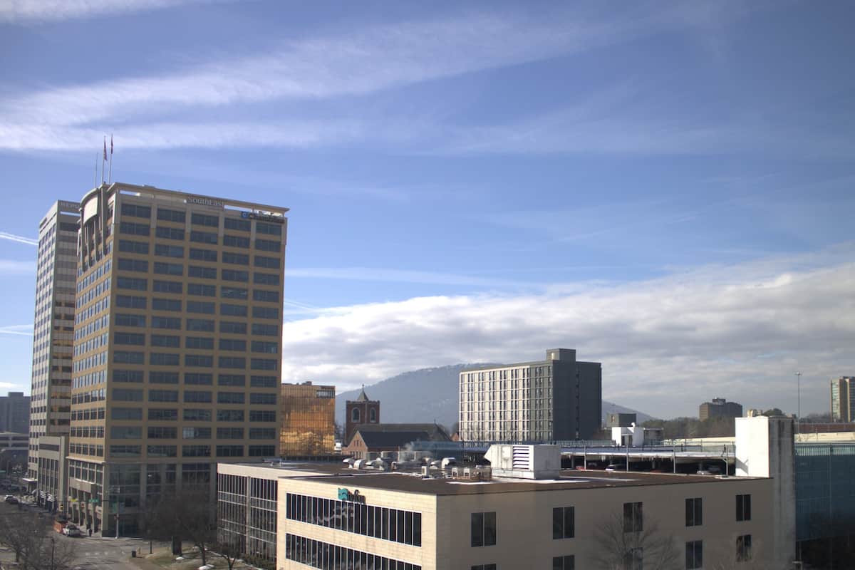 Un paysage urbain avec des bâtiments modernes, dont un grand hôtel dont l’enseigne est bien visible.