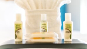 A bathroom vanity with three bottles of coconut lime verbena shampoo and a bar of soap. - Holiday Inn & Suites Chattanooga Downtown by IHG (Chattanooga)