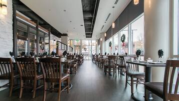 A spacious restaurant with high ceilings, large windows, and a modern interior design.