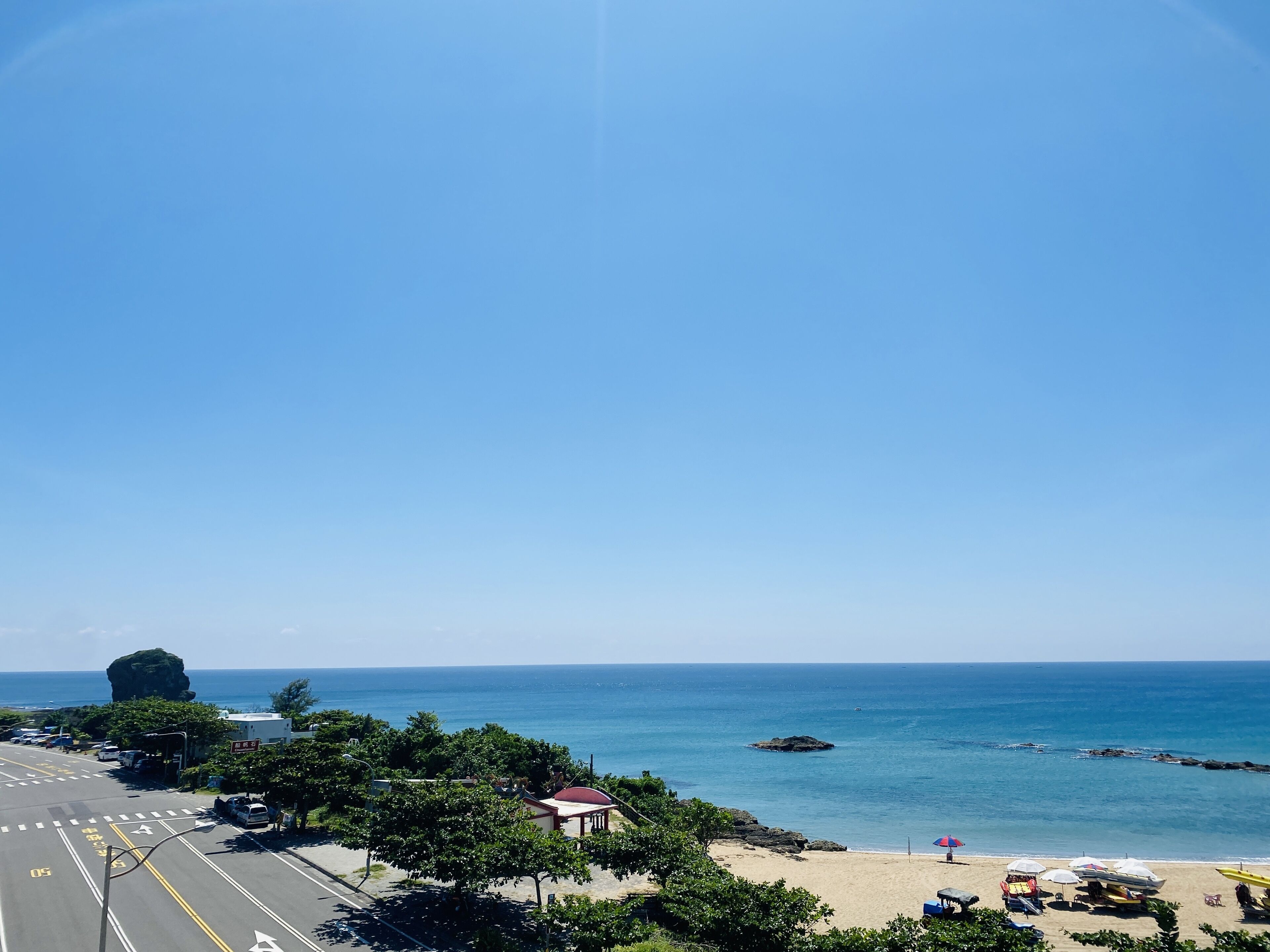 A coastal road with a beach and ocean view.
