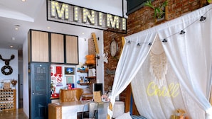 A cozy room with a bed, a desk, and a wardrobe. There is a sign above the bed that reads "MINIMA". - Minimi Inn - SailRock Beach House (Hengchun)