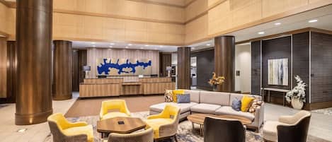 A spacious lobby with a reception desk, seating area, and modern decor.