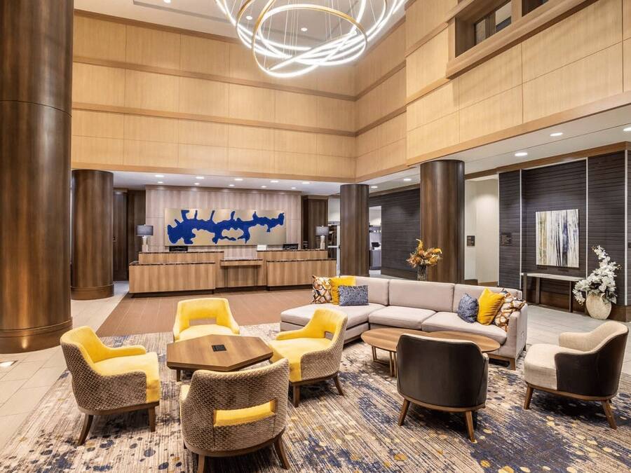 A spacious lobby with a reception desk, seating area, and modern decor.