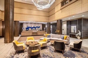 Un vestíbulo amplio con mostrador de recepción, zona de estar y decoración moderna.