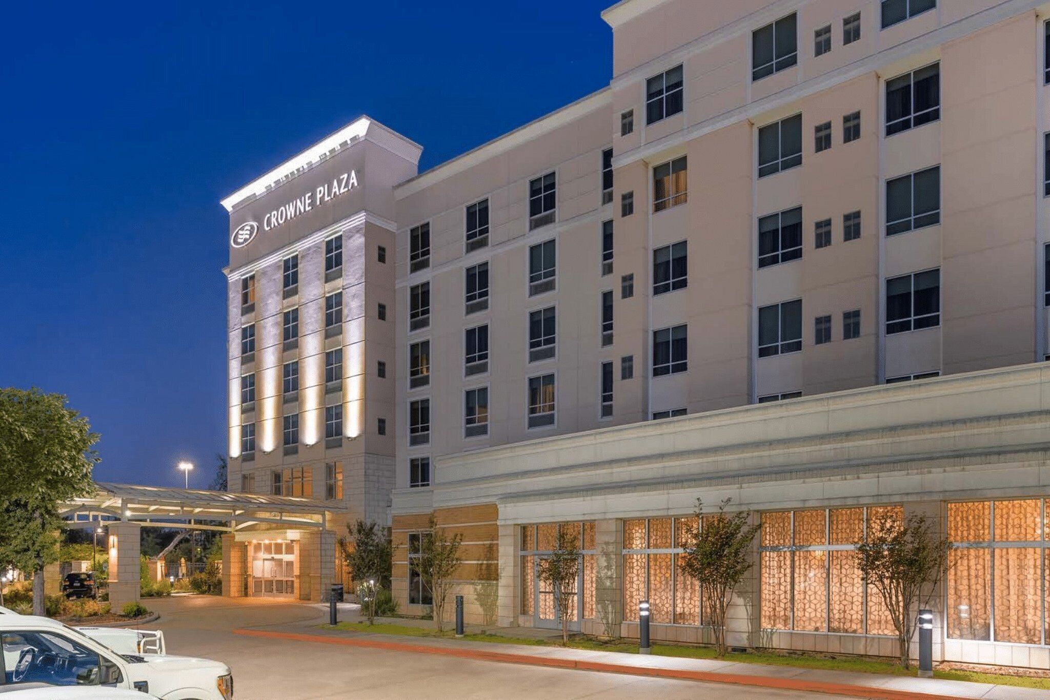 Un hotel de varios pisos con un cartel llamativo que dice 'CROWNE PLAZA' en la parte superior.