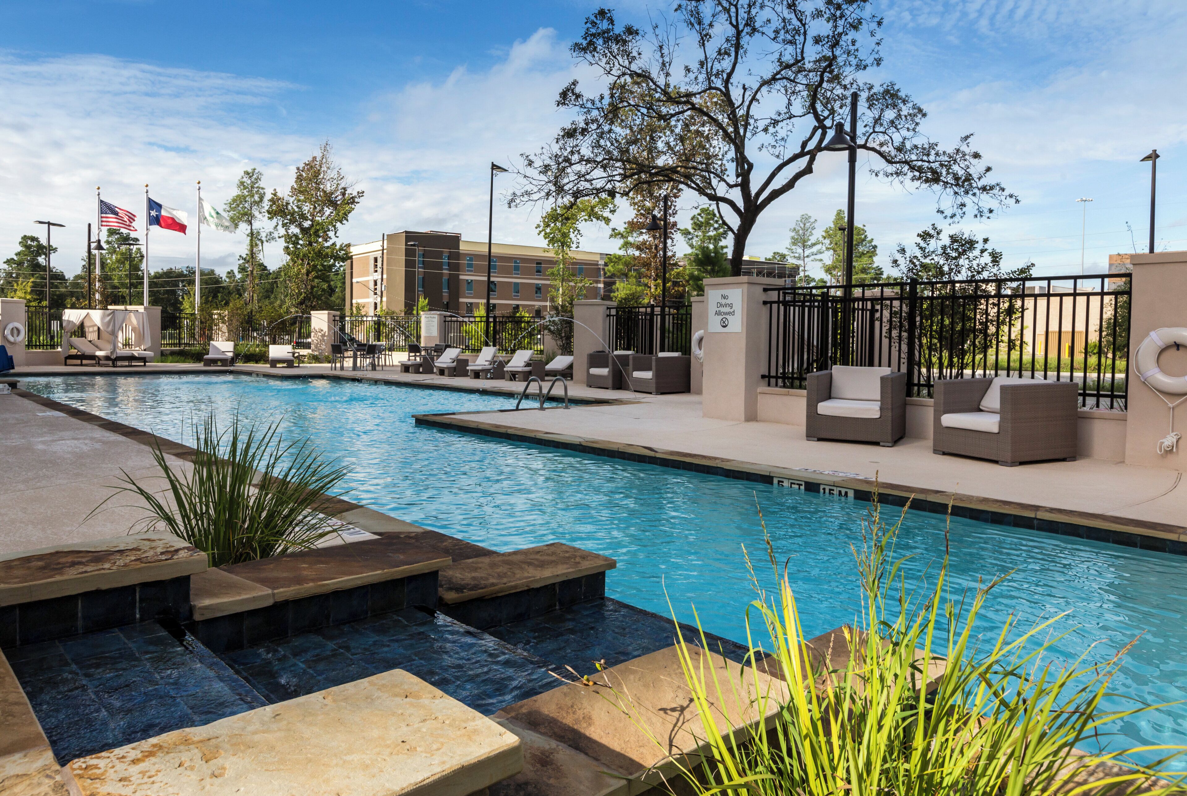 A swimming pool with lounge chairs and a 'No Diving Allowed' sign.