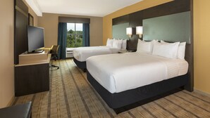 A hotel room with two beds, a TV, a desk, and a window with curtains. - Crowne Plaza Shenandoah - Woodlands Area by IHG (Shenandoah)