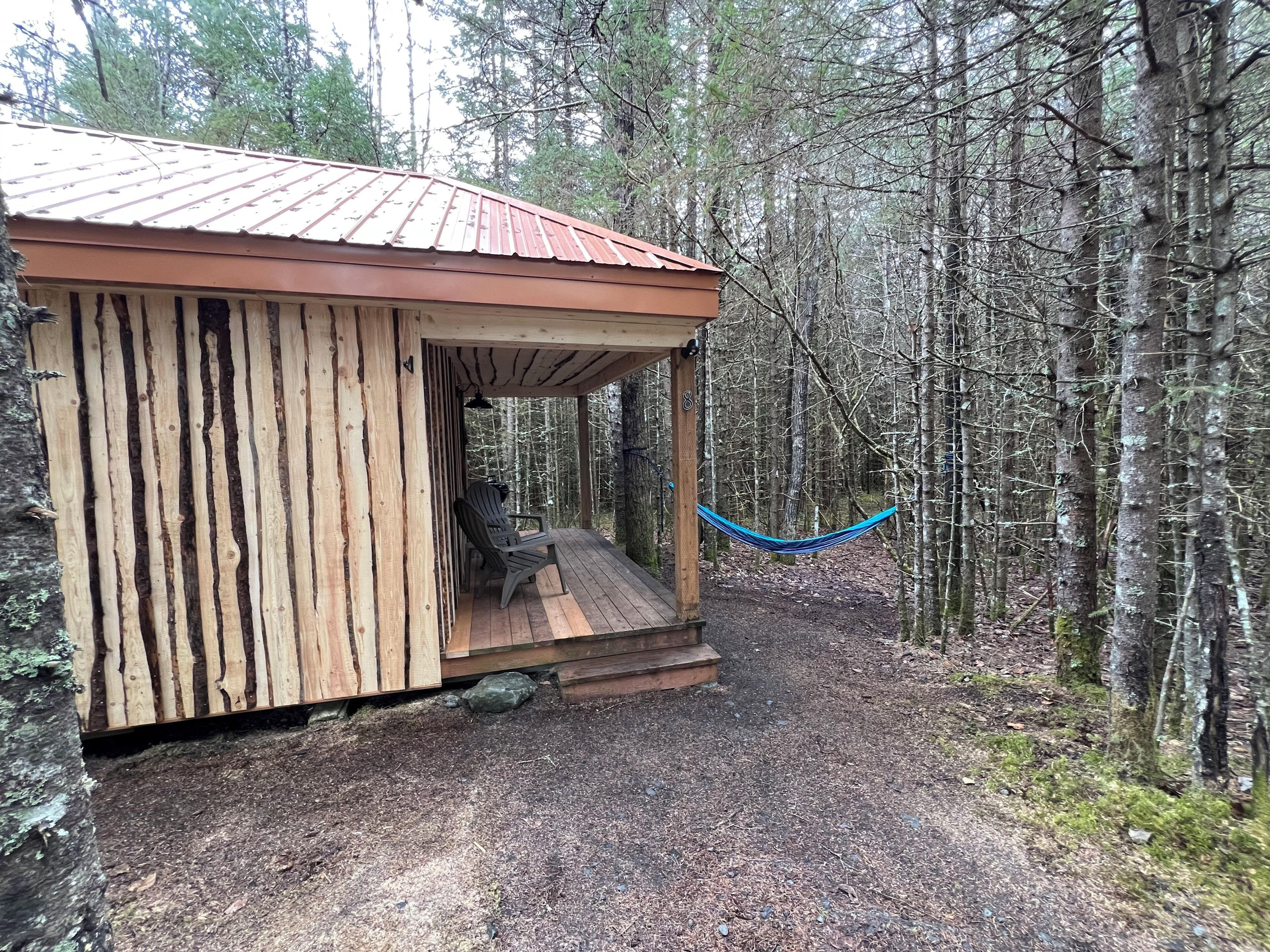 Eine Holzhütte mit Veranda und Hängematte.