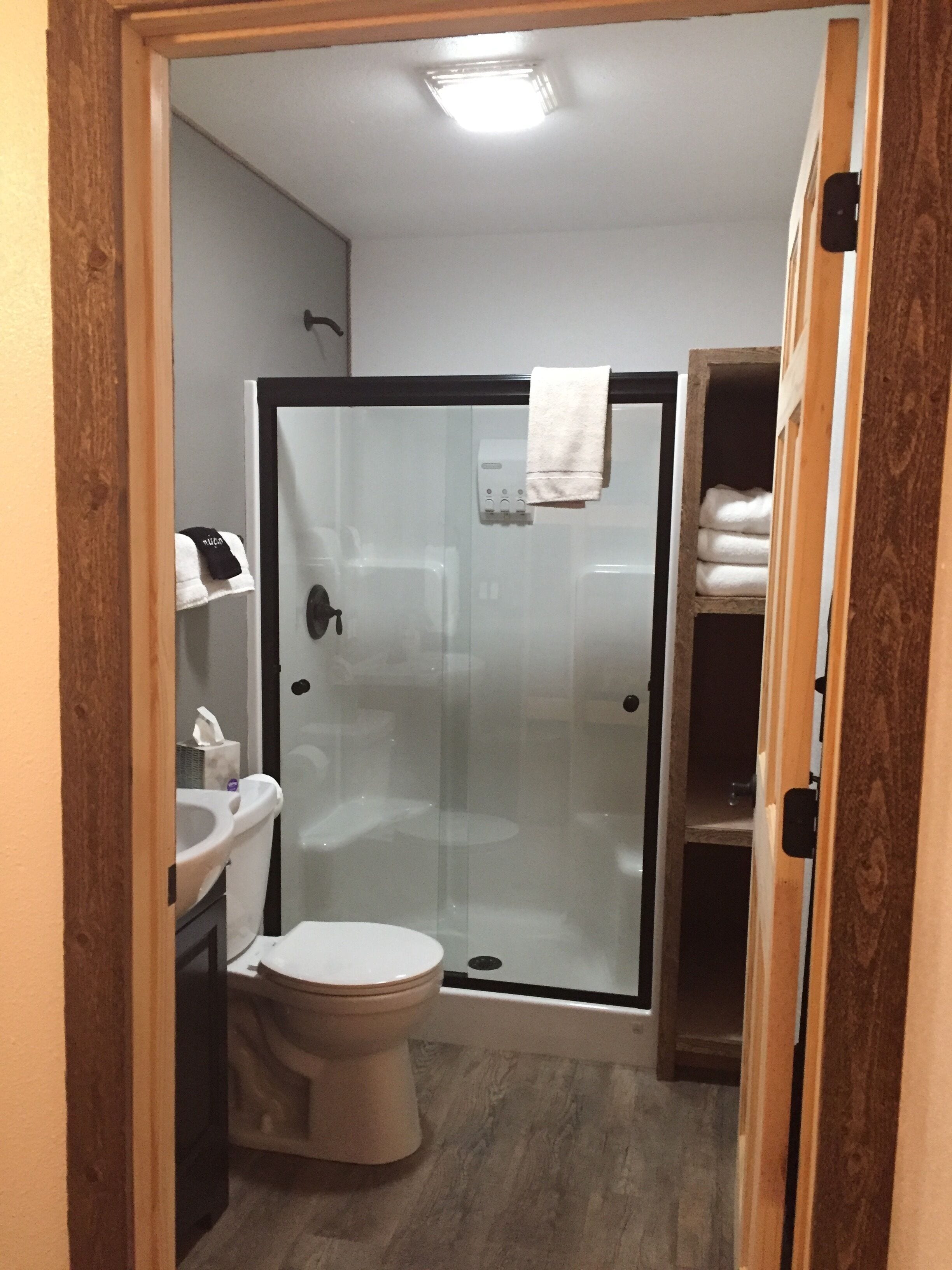 Une salle de bain compacte avec une douche à parois de verre, des toilettes et un lavabo.