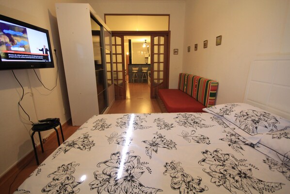 A hotel room with a bed, a TV on the wall, a small table, and a bench. - Ribeiro 612 (Rio de Janeiro)