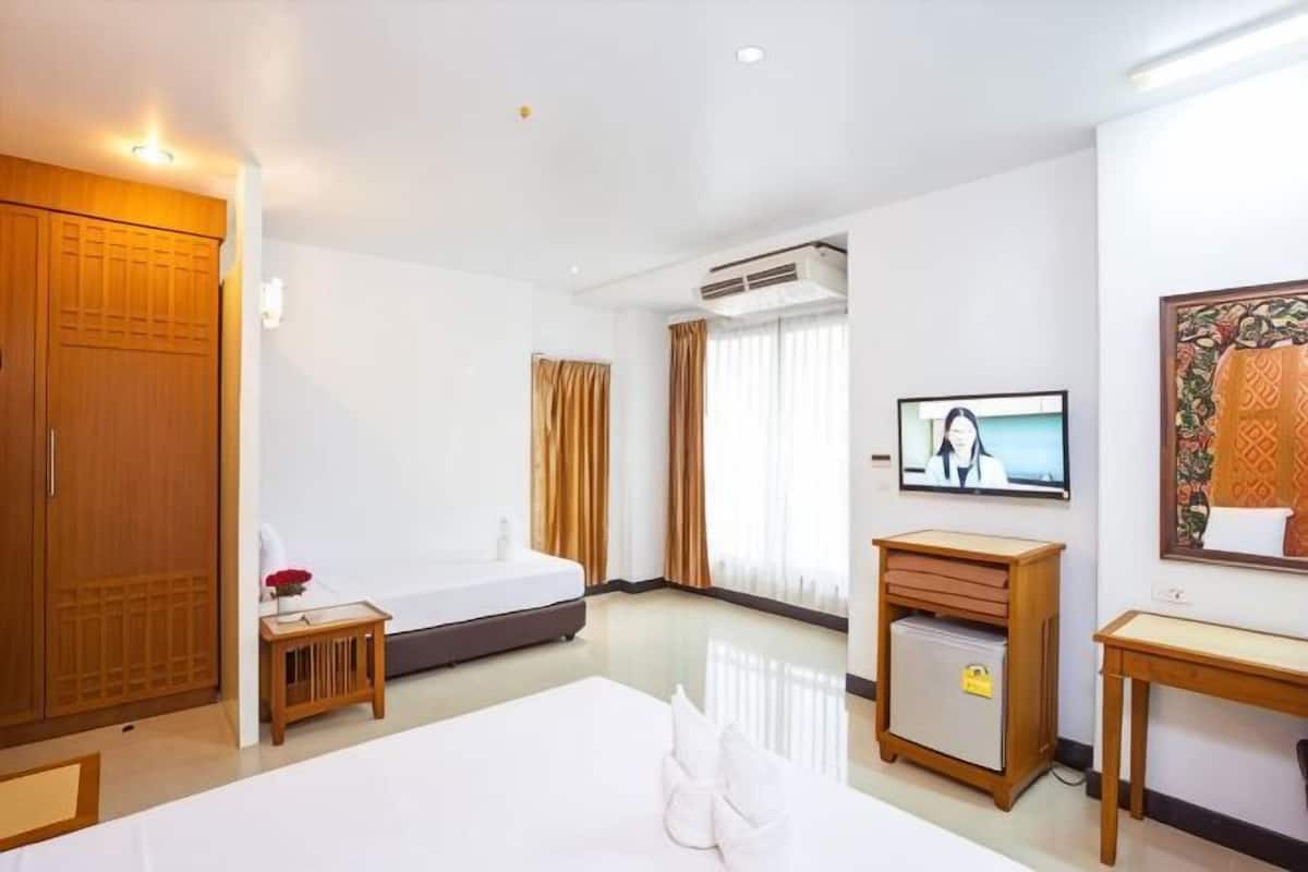 Une chambre d’hôtel équipée d’un lit, d’un bureau, d’une armoire, d’une télévision et d’un appareil de climatisation.