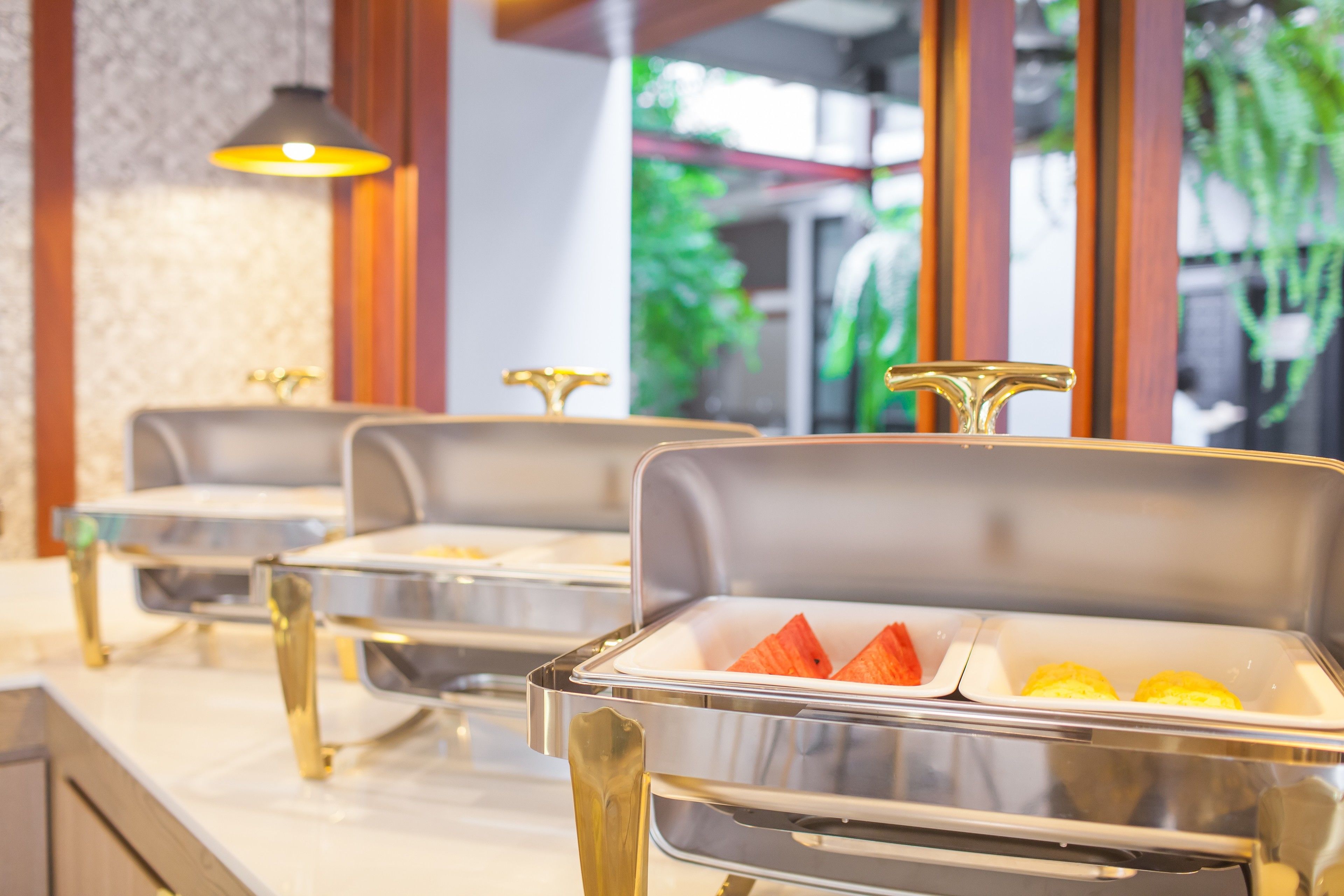 Buffet stations with food containers and a pendant light.
