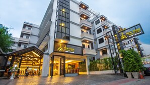 Hotel de vários andares com design moderno, com varandas e amplas janelas.