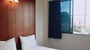 A hotel room with a bed, a ceiling fan, a window with curtains, and a view of the outside. - New Siam I (Bangkok)