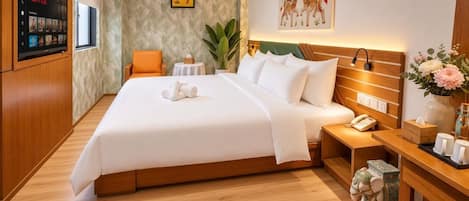 A modern hotel room with a large bed, bedside table, and a wall-mounted TV.