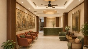 A lobby with a reception desk, seating area, and artwork on the walls. - Two Elephants Hotel (Ho Chi Minh City)